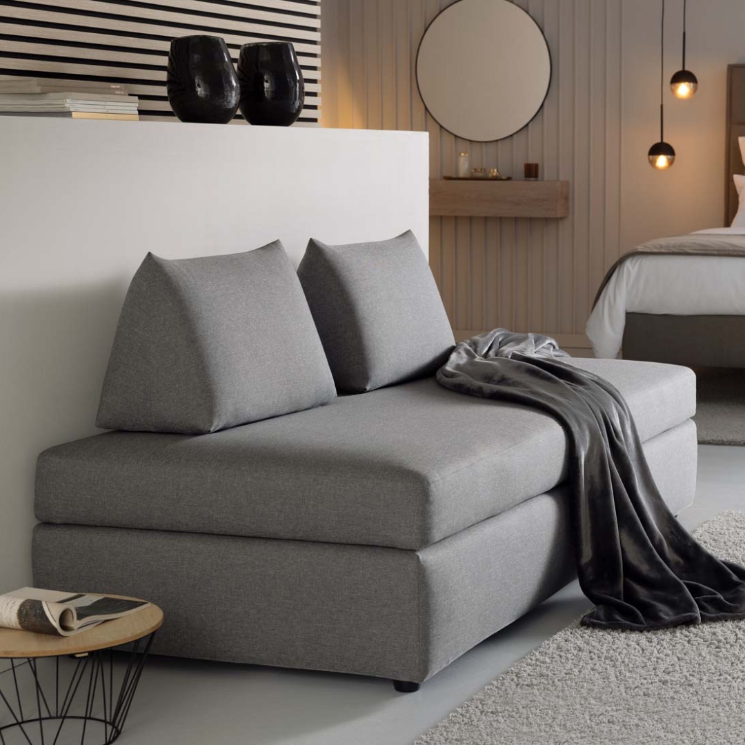 Schlafcouch Limone mit grauem Bezugstoff im Hotelzimmer und zwei Sirmione Kissen