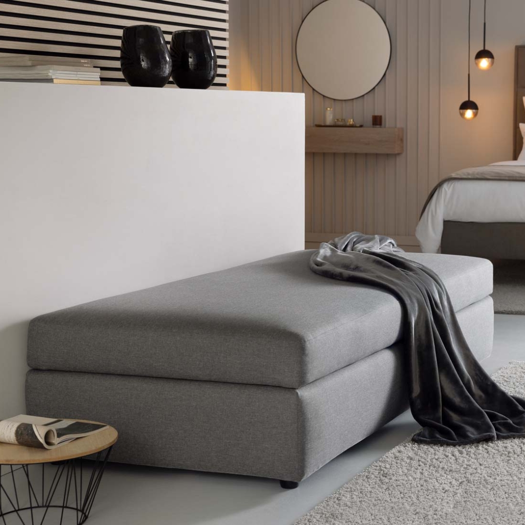 Schlafcouch Limone mit grauem Bezugstoff im Hotelzimmer