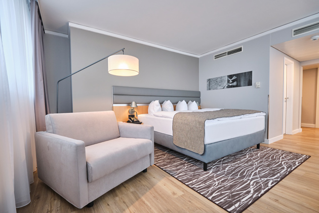 Schlafsessel Riva mit beigem Bezug im hellen Hotelzimmer des Holiday Inn Berlin Airport