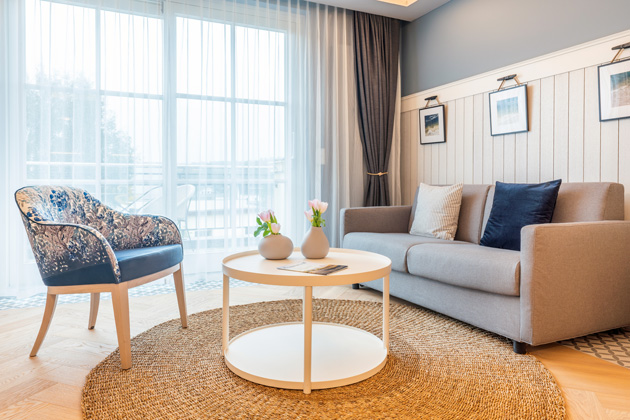 Schlafsofa Riva mit beigem Bezug im geräumigen Hotelzimmer des Seetel Hotels in Heringsdorf